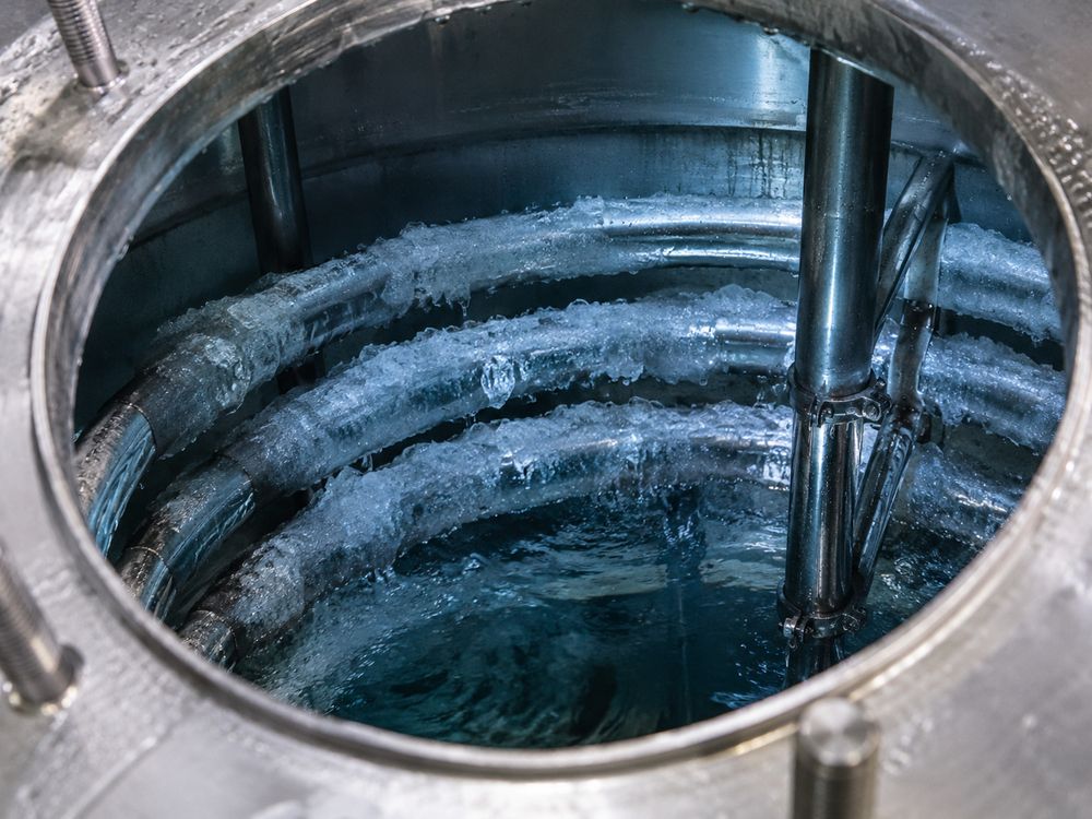 Haz de serpentín de banco de hielo sumergido con una capa visible de hielo, visto por la tapa de tanque abierta